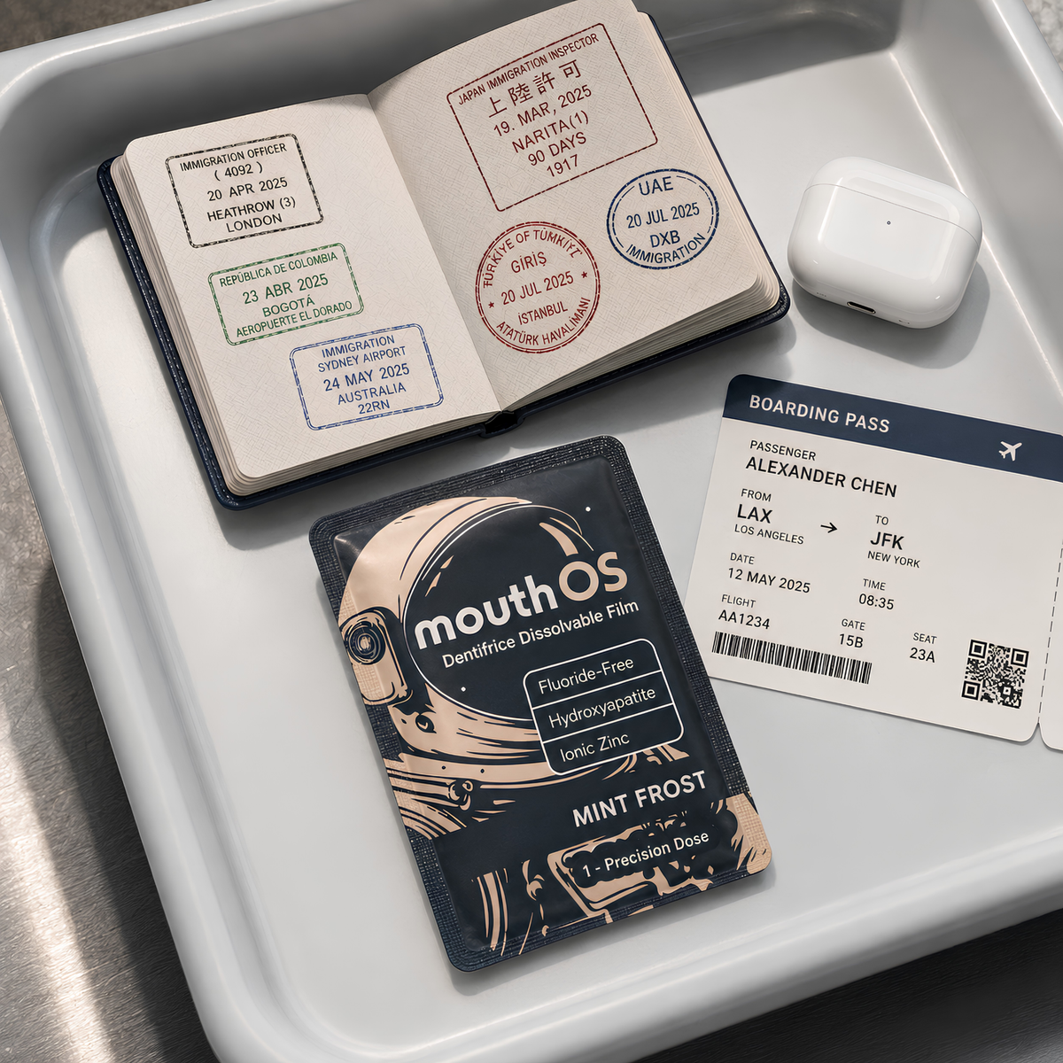 Mouth OS toothpaste film sachet in an airport security tray with a passport, boarding pass, and travel essentials