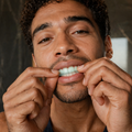 Man applying Mouth OS Mint Frost Dissolvable Film to front teeth in luxury bathroom | Clean Saint | waterless oral care