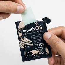 A Mouth OS Mint Frost dissolvable toothpaste film lifted from its individually sealed pack, one Precision Dose