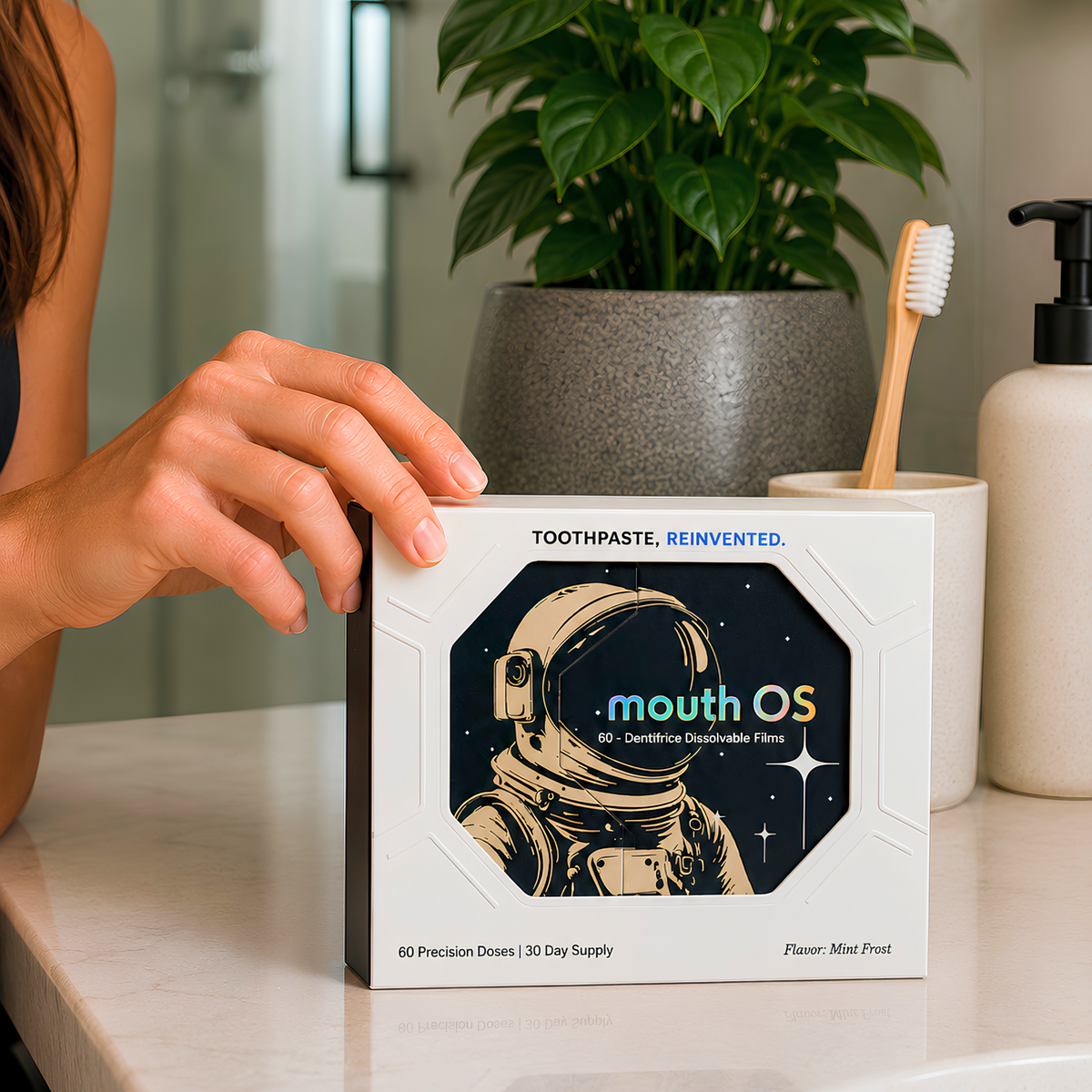 Clean Saint Mouth OS toothpaste film box on a modern bathroom vanity beside a toothbrush