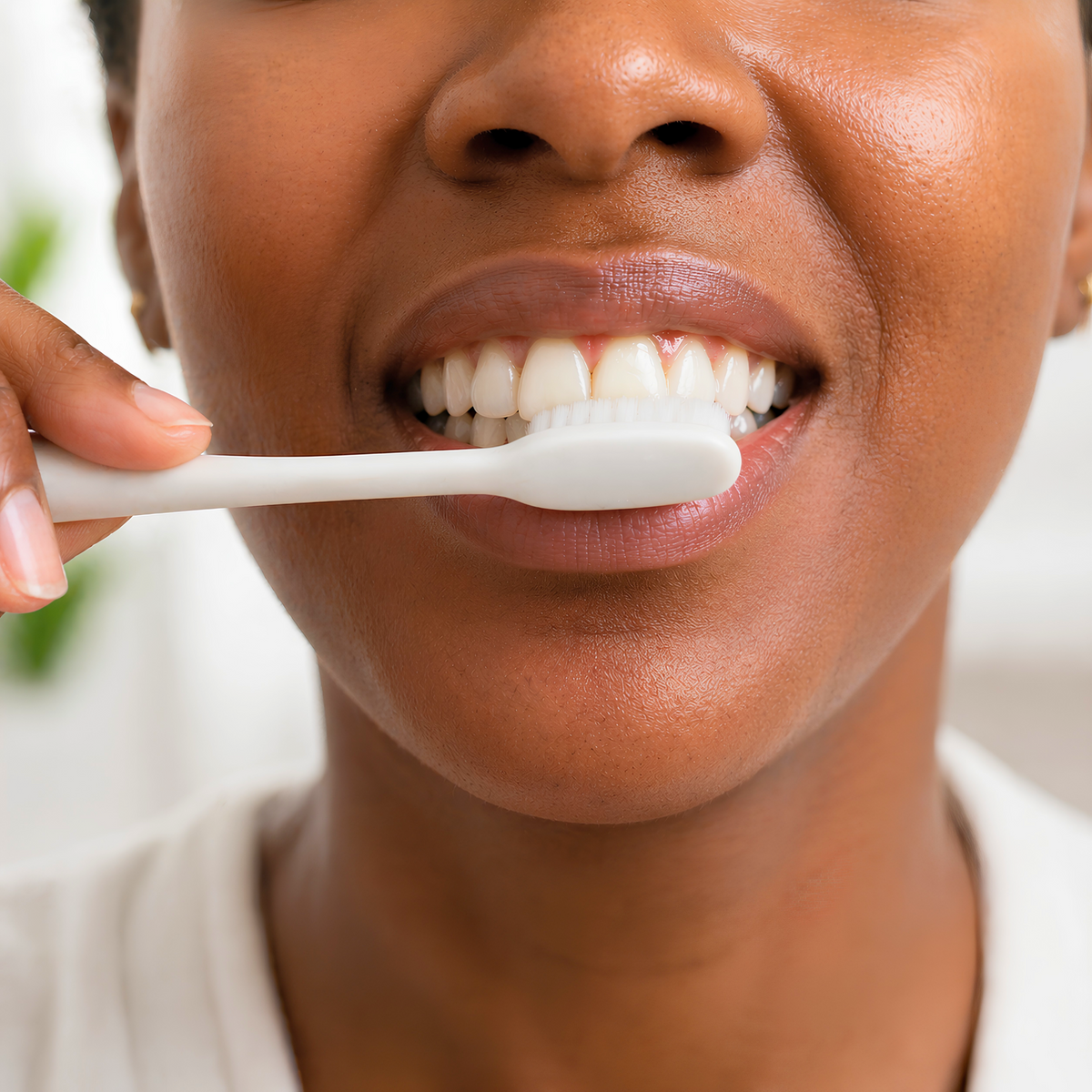 Brushing teeth after applying Mouth OS toothpaste film as part of a normal oral care routine